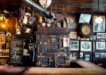 Be Good or Be Gone, the motto of McSorley's. above the motto by the pipe from the stove, are the handcuffs from Houdini.