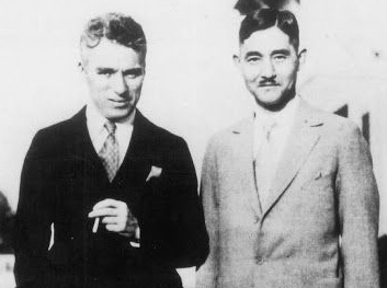 Actor Charlie Chaplin and his valet, Kono, meet with Nageli and Amakasu in Tokyo to discuss films.