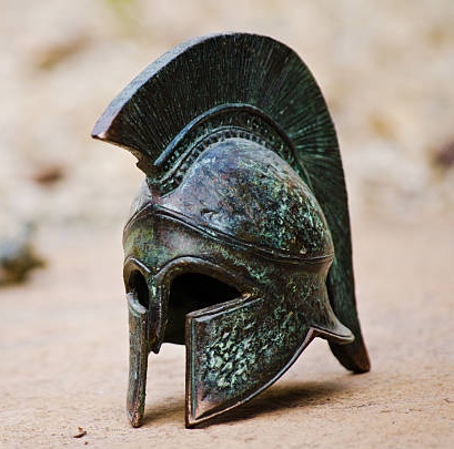 A small bronze helmet, a copy of classic greek armour, in the style used by semi-mythical characters such as Achilles