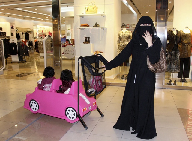 A Saudi woman shops at a mall with her children in Jeddah March 8, 2009. Arab countries are sharing in the celebration of International Women's day. REUTERS/Susan Baaghil (SAUDI ARABIA SOCIETY)